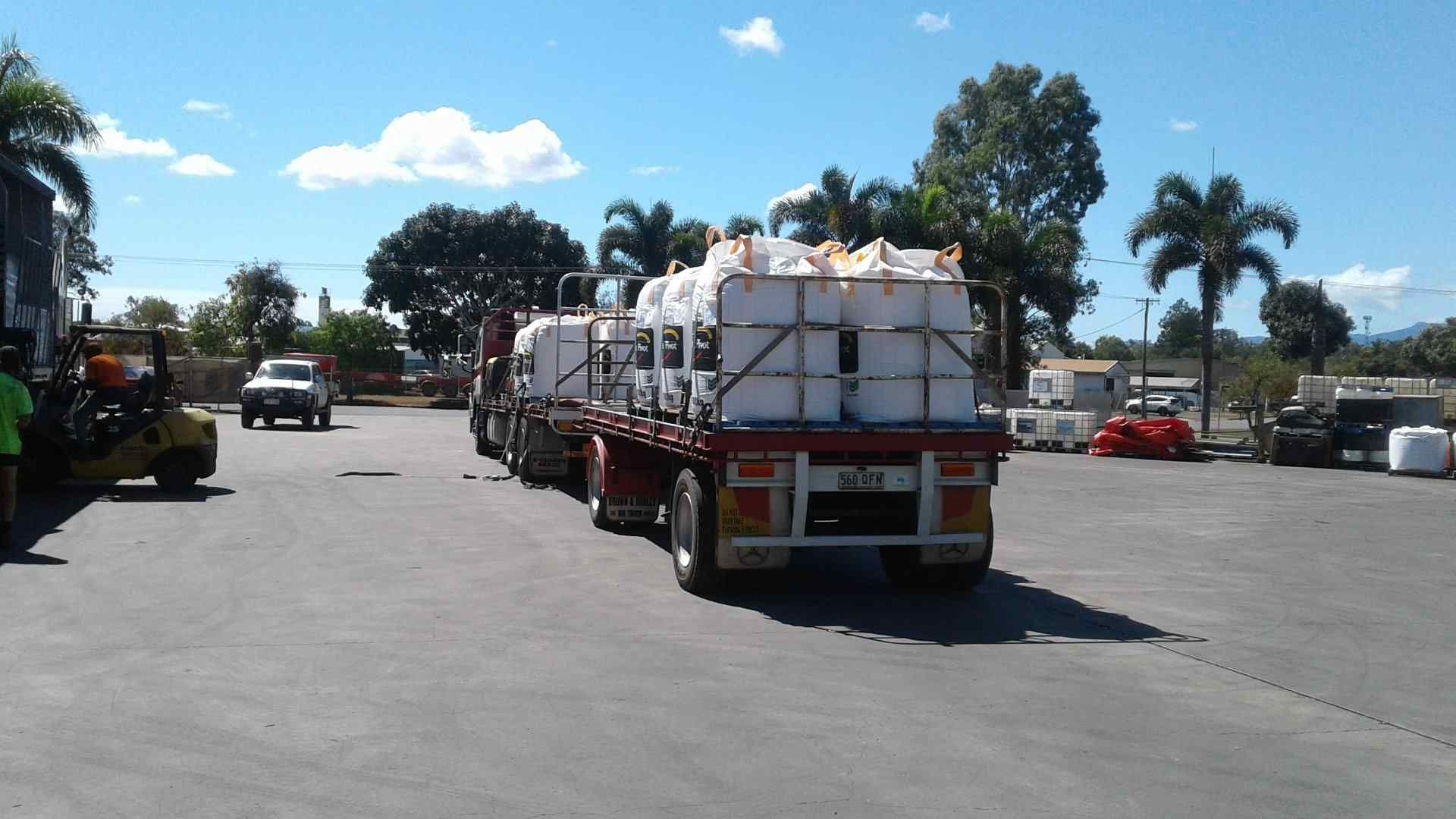 A Truck With a Trailer Full of White Bags — Reliable Machinery Transport in Mareeba, QLD