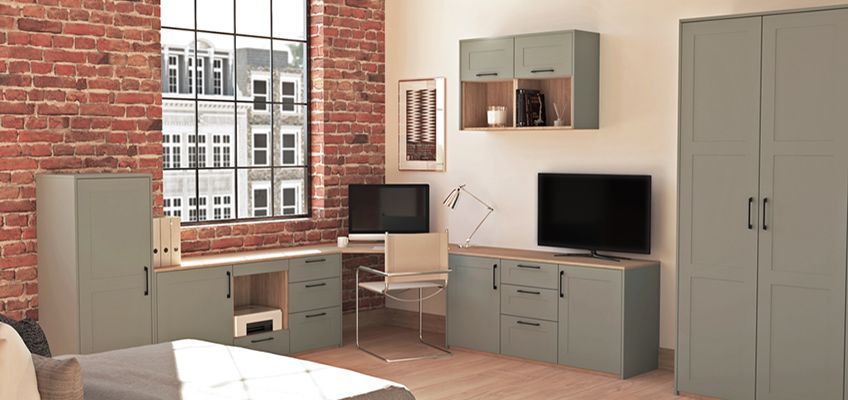 A living room with a couch , desk , cabinets , and a television.