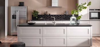 A kitchen with white cabinets and a stainless steel refrigerator