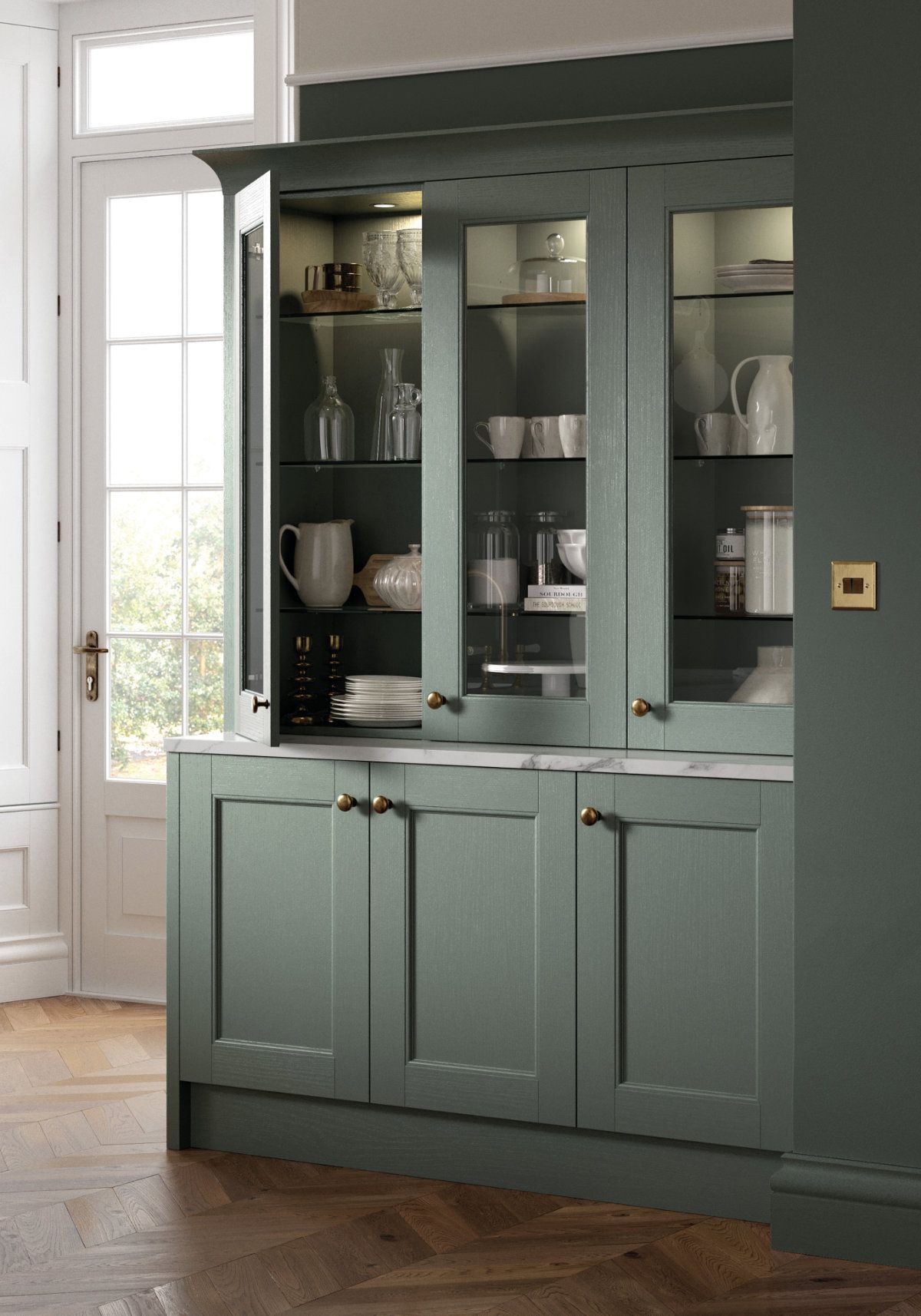 A kitchen with green cabinets and a glass hutch