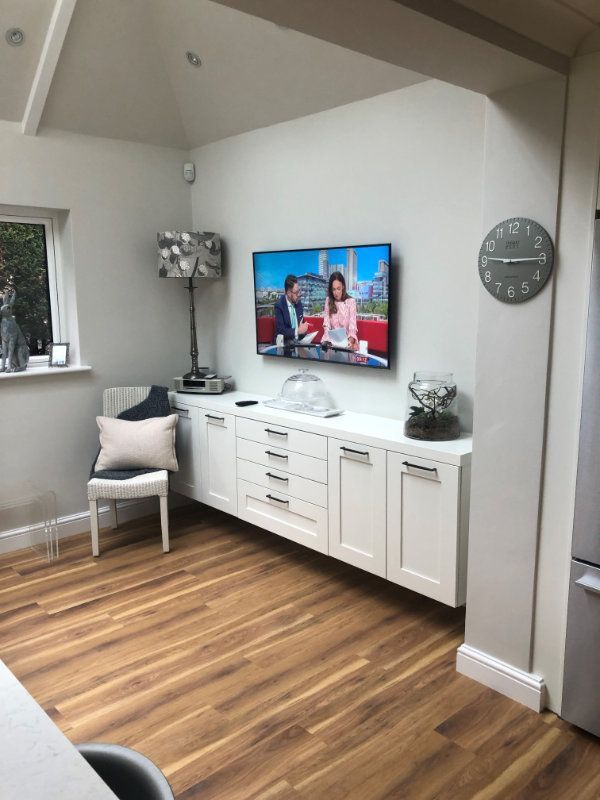 A living room with a flat screen tv on the wall.