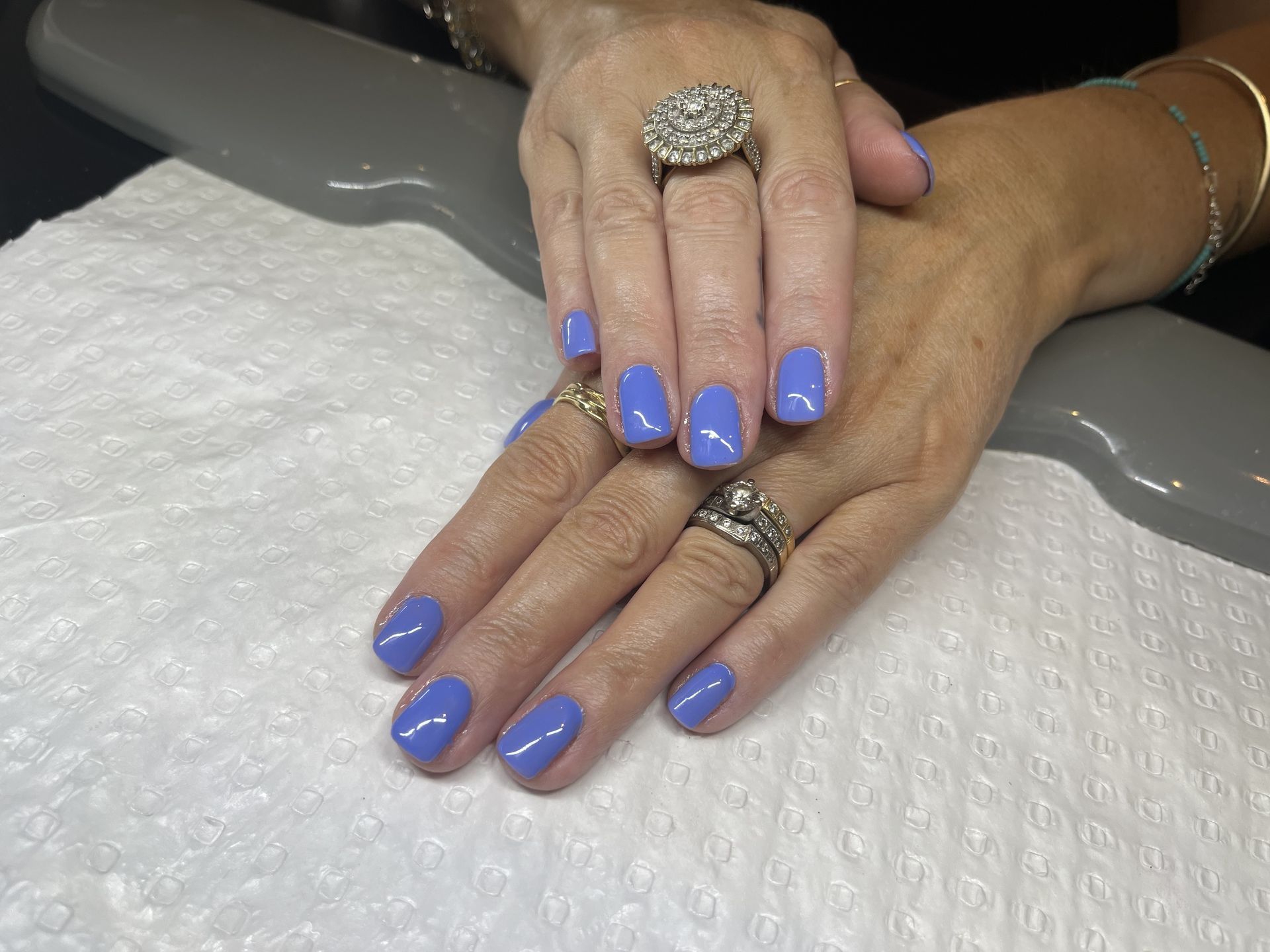 A woman's hands with blue nails and rings on them — Nailz By Dezign In Proserpine, QLD