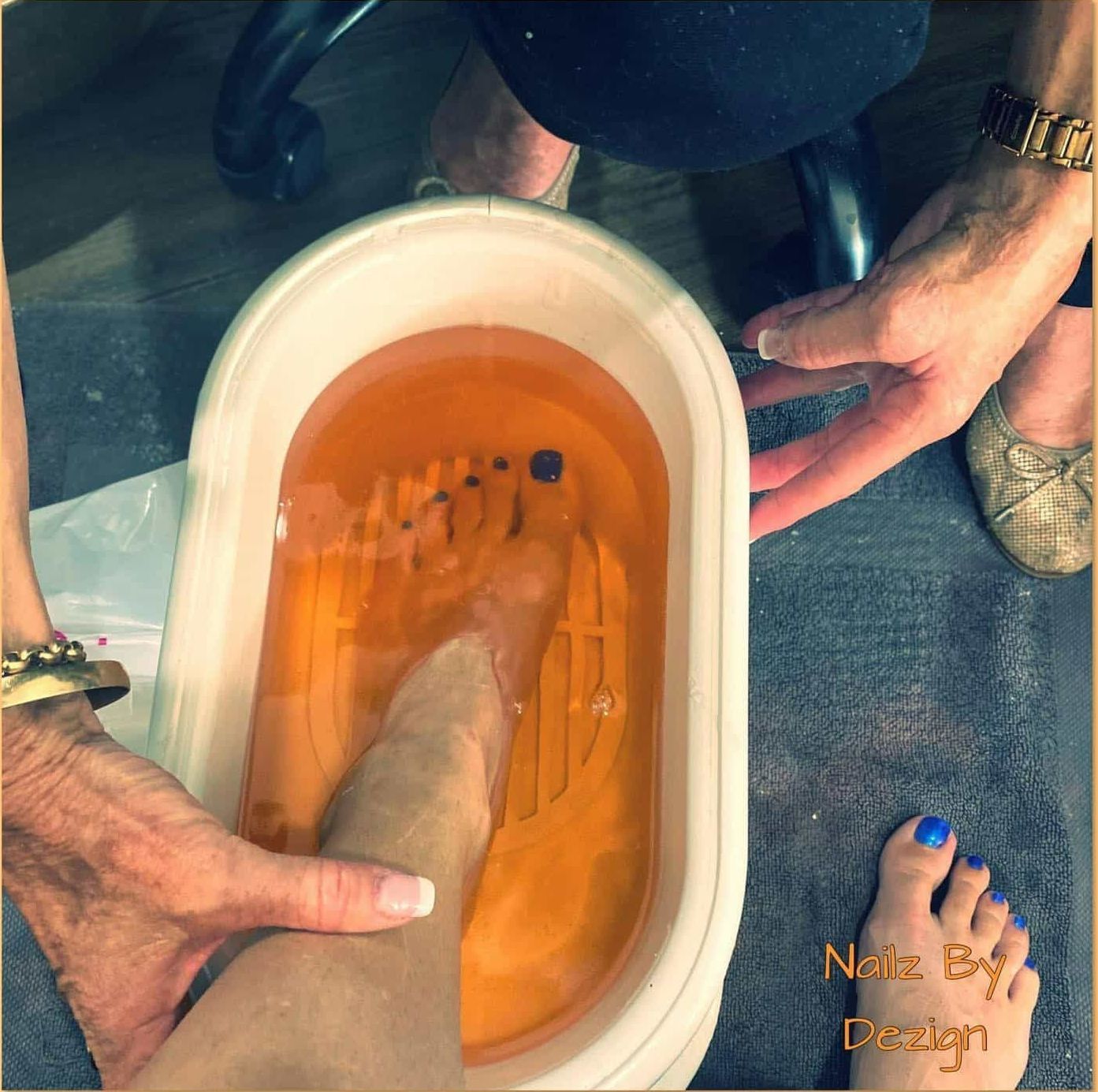 A Woman's Feet Are in a Bathtub With Nails by Design Written on the Bottom — Nailz By Dezign In Airlie Beach, QLD