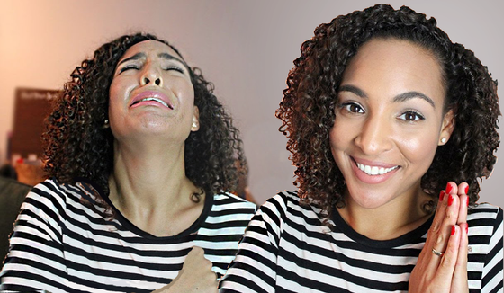 A woman with curly hair is wearing a striped shirt and smiling.