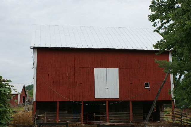 A red barn with white doors and a white roof.