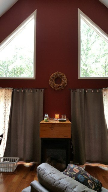 A living room with red walls and a fireplace