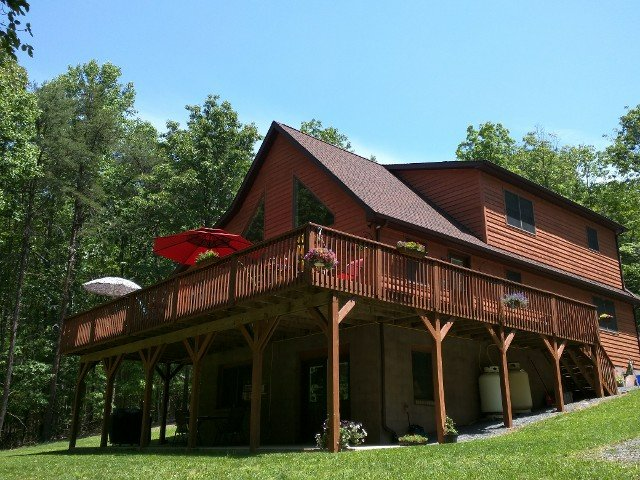 A large house with a large deck and umbrellas on it