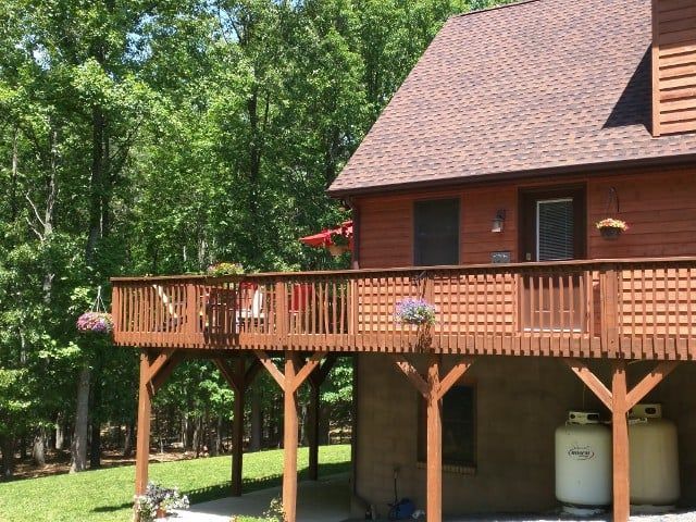 A wooden house with a large deck in front of it