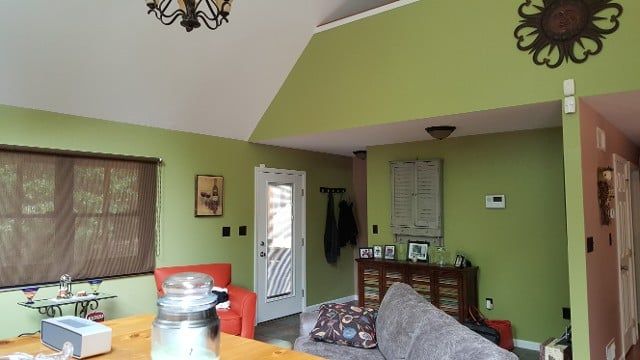 A living room with green walls and a gray couch