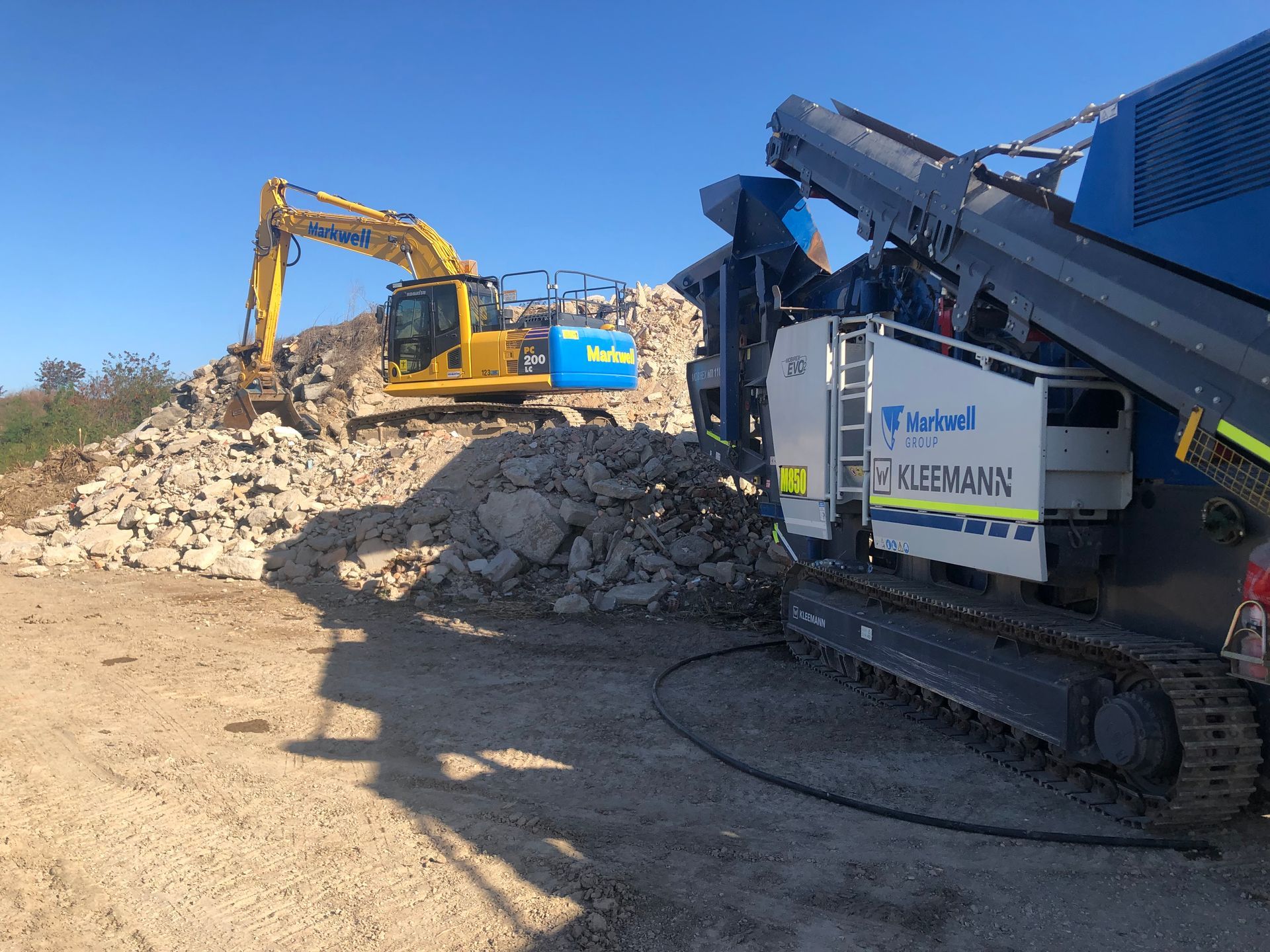 An aerial view of a construction site with a yellow bulldozer and a conveyor belt.