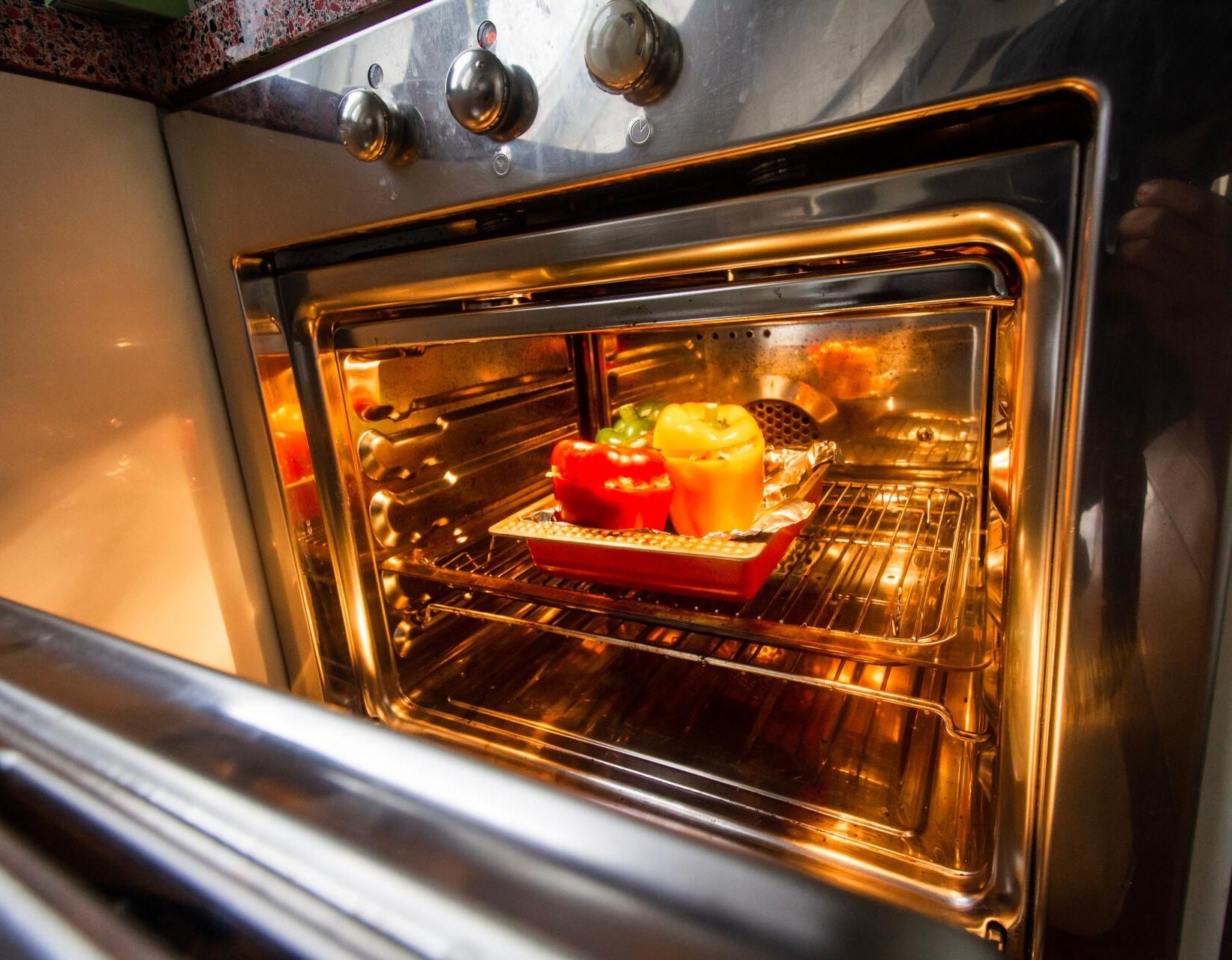 Peppers are being cooked in an oven with the door open