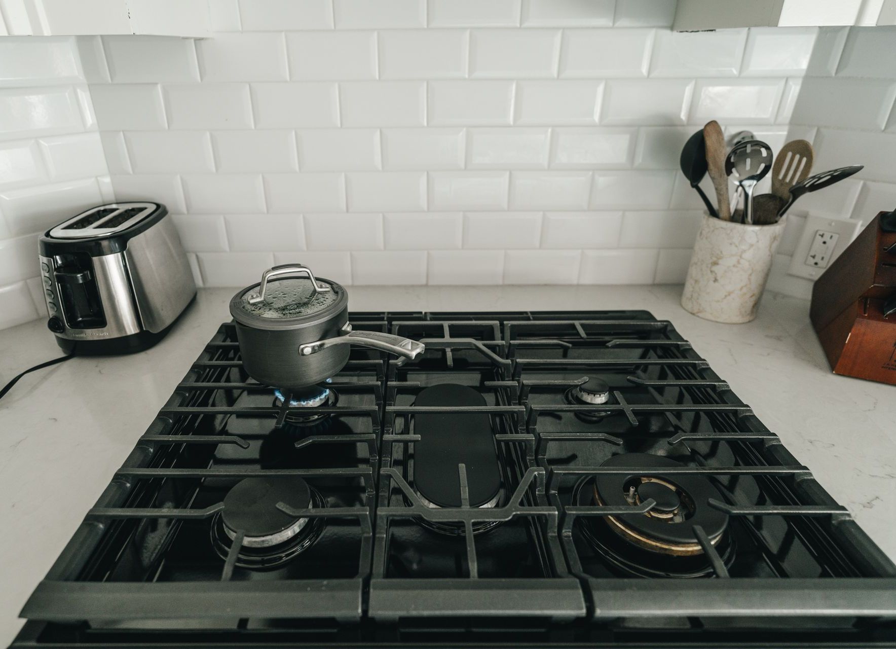 A gas stove with a pot and pan on it in a kitchen.