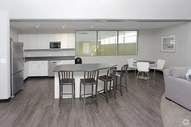 Modern kitchen with island, stainless steel appliances, and seating.