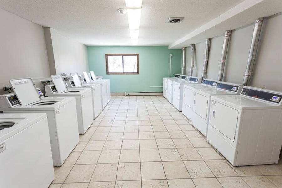 On-site laundry room with rows of washing machines along both walls.