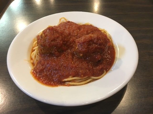 A white plate topped with spaghetti and tomato sauce