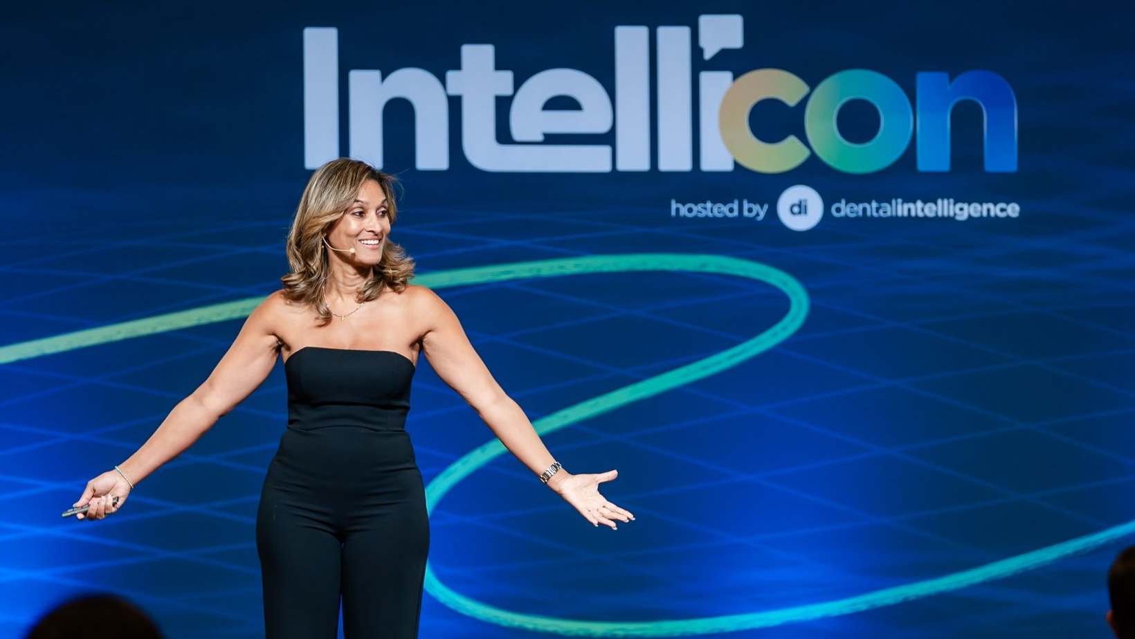 Group of people at an event, smiling and posing.  Some have lanyards. Indoors, bright lighting.