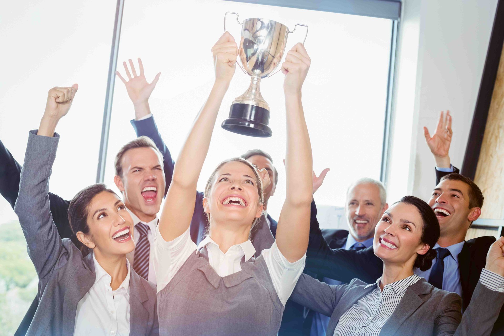 a group of people are holding up a trophy in the air