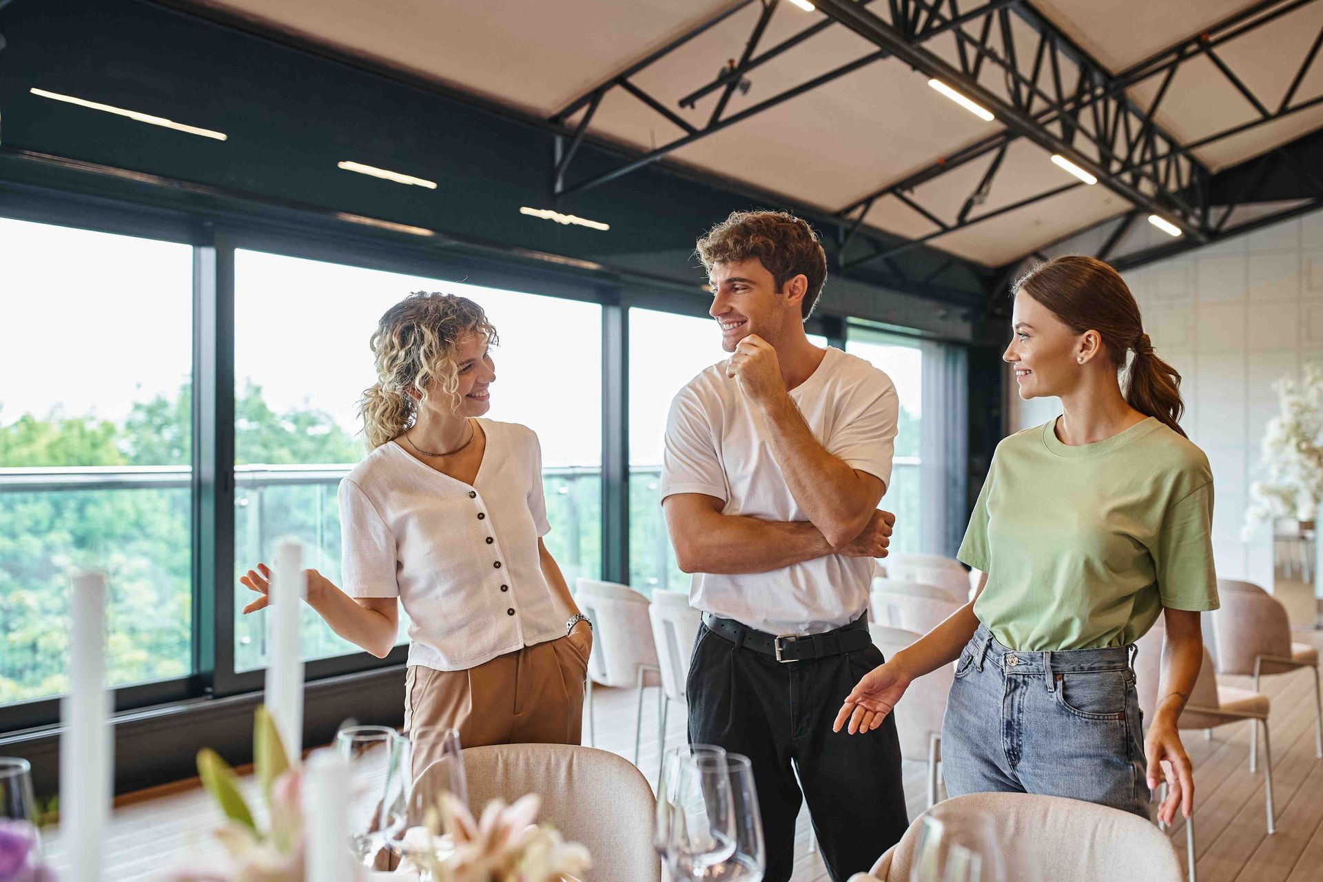 a group of people are standing in a room talking to each other