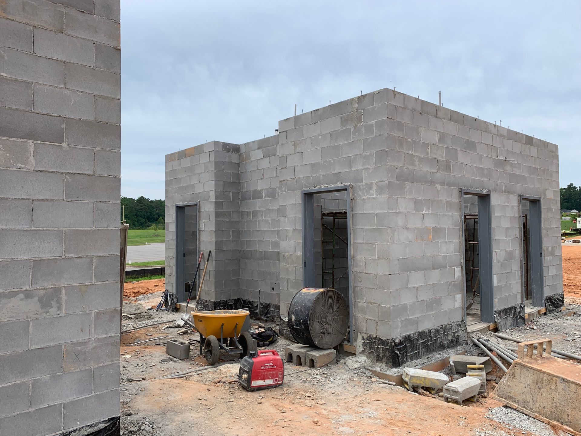A building is being built with bricks and a wheelbarrow.