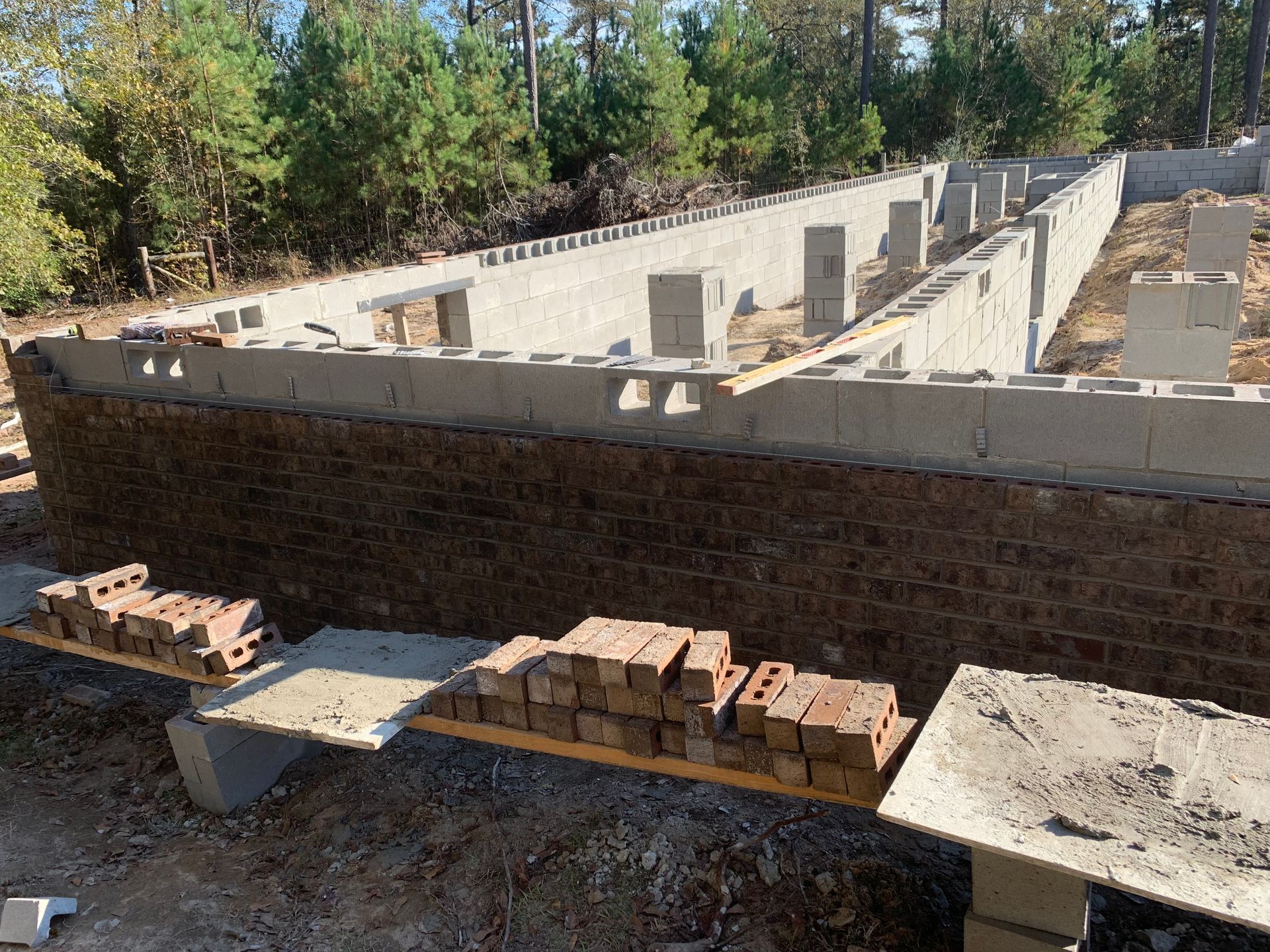 A brick wall is being built on a construction site.