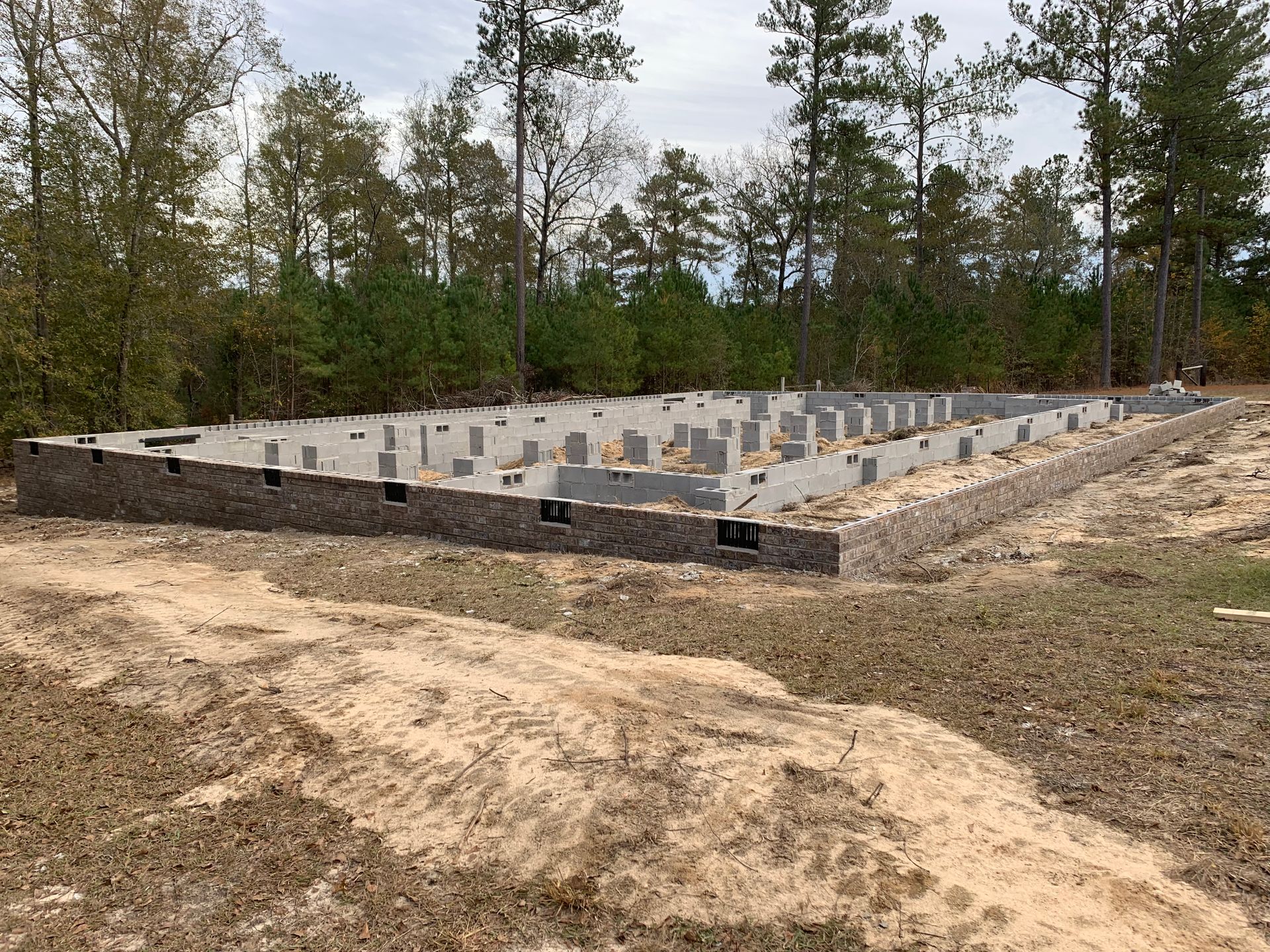 A foundation for a house is being built in the middle of a dirt field.