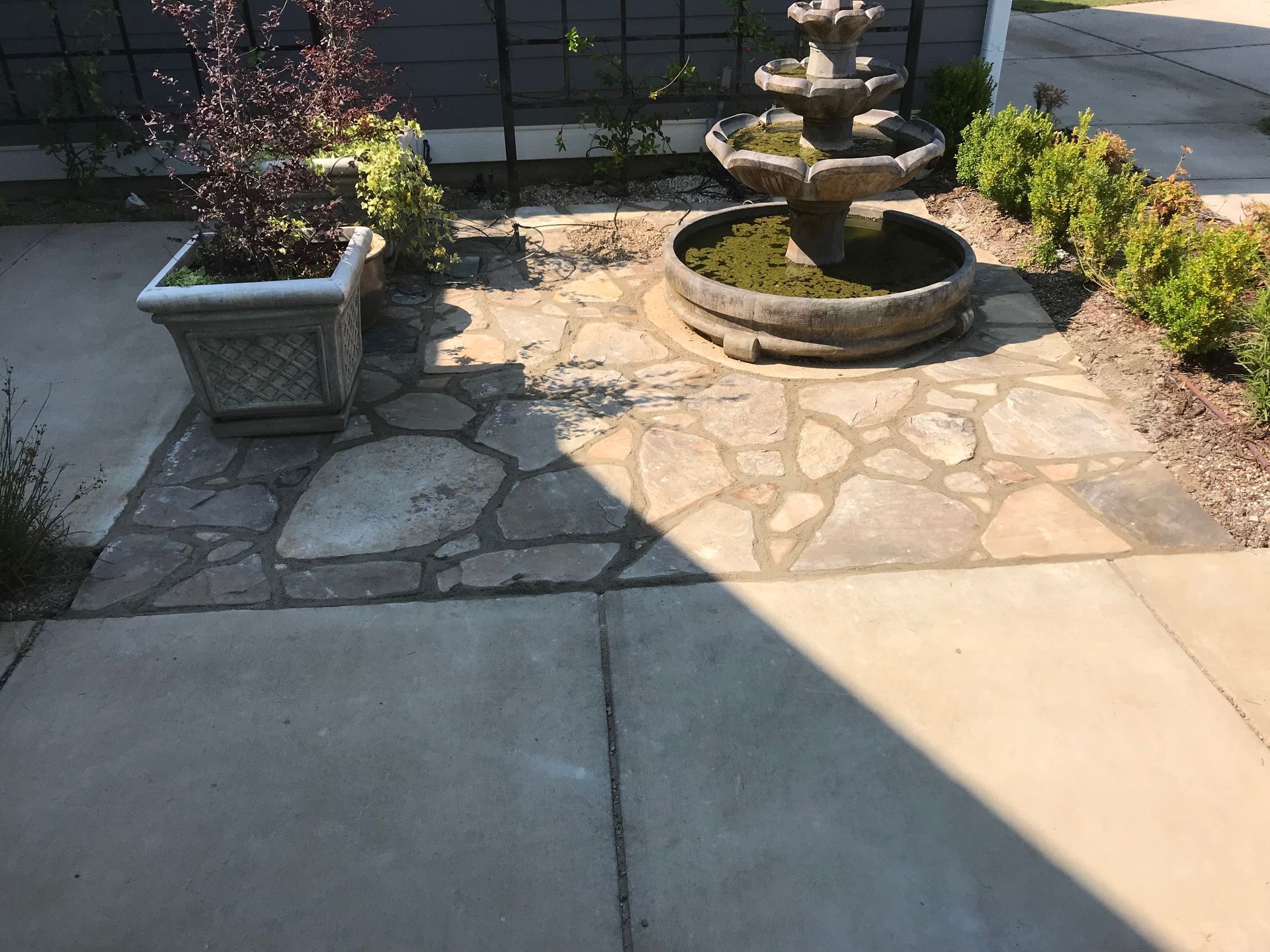 There is a fountain in the middle of the patio.