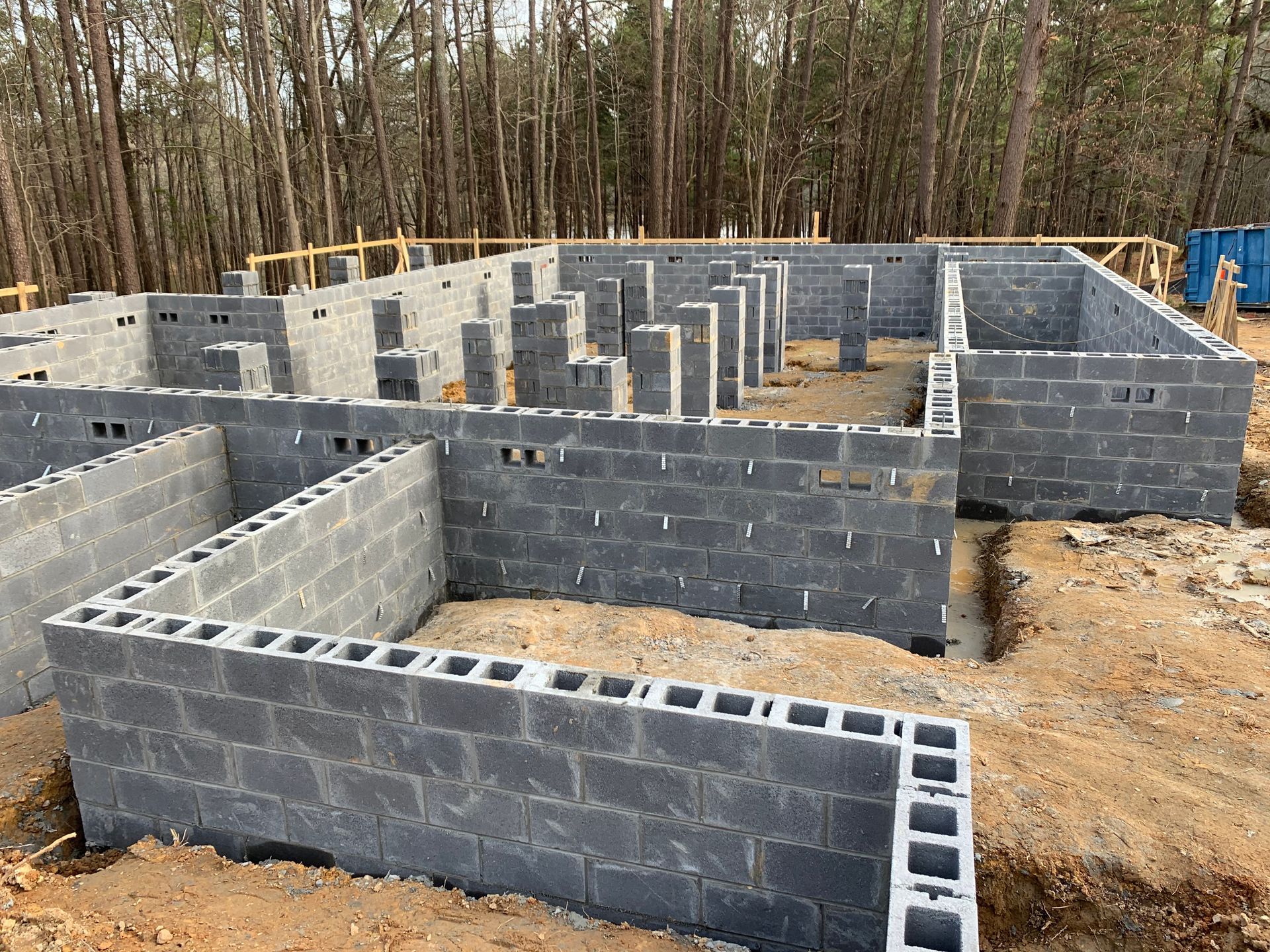 A foundation of a house is being built in the middle of a forest.