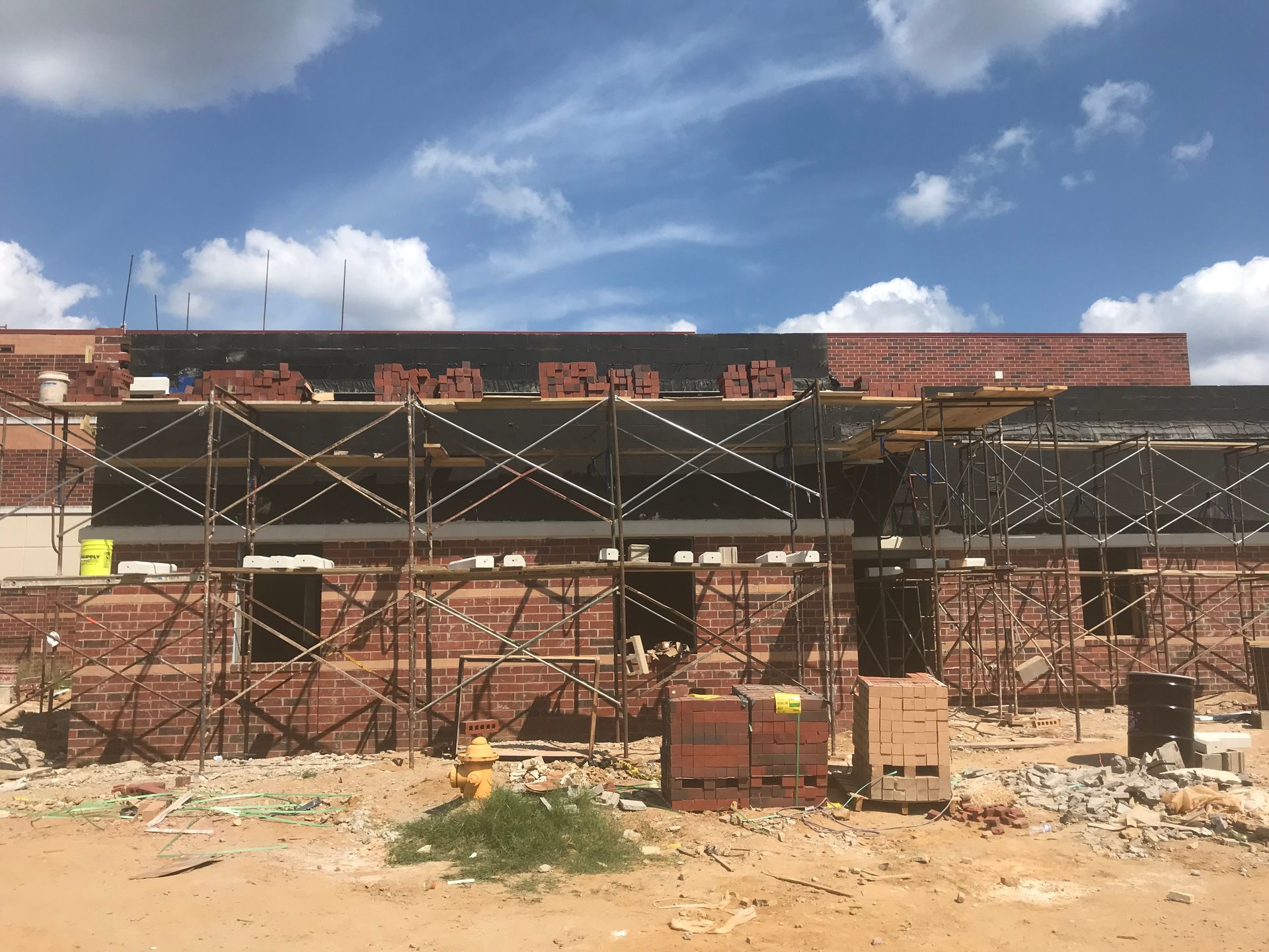 A brick building under construction with scaffolding around it