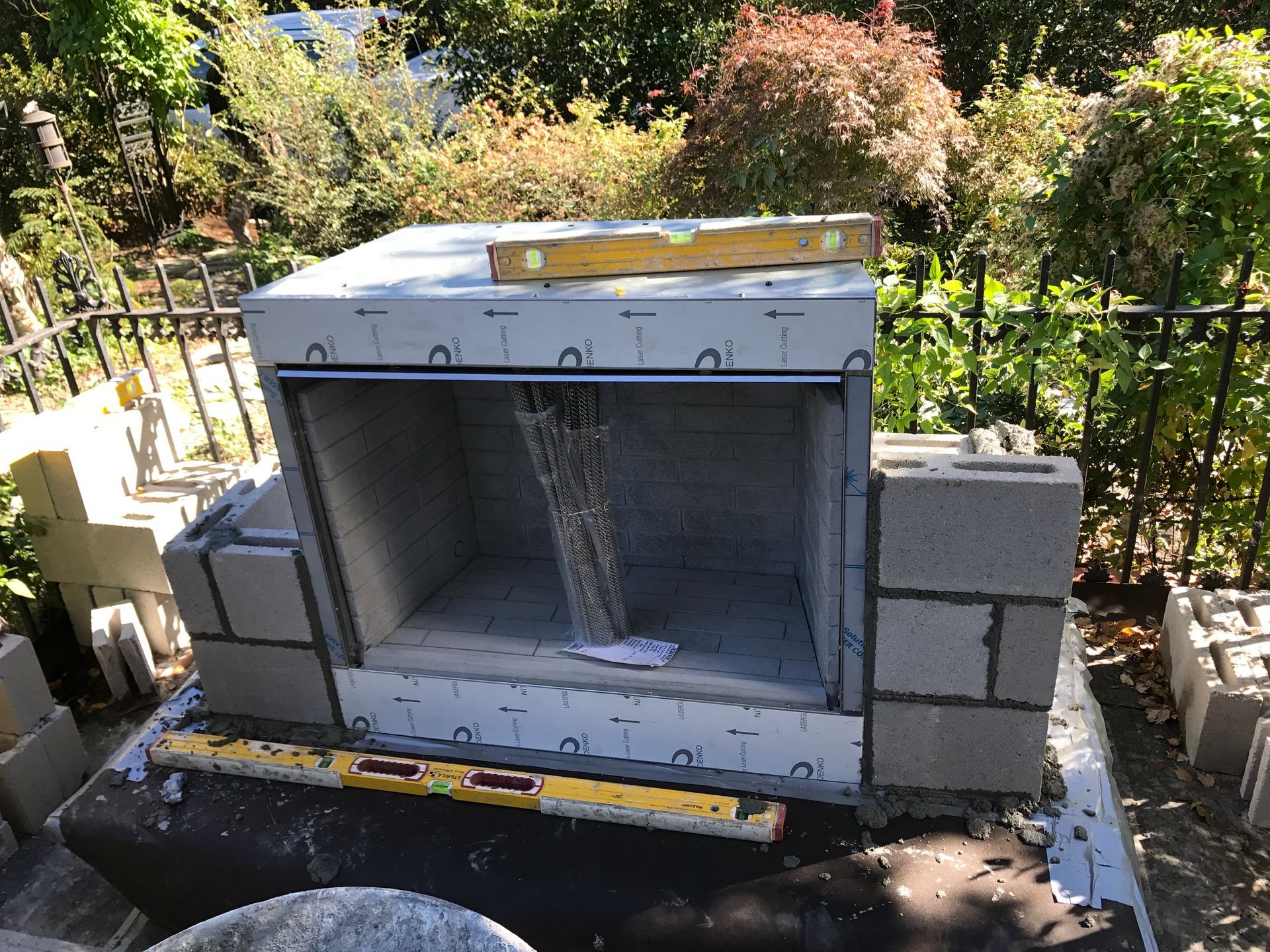 A fireplace is being built with bricks and a level.