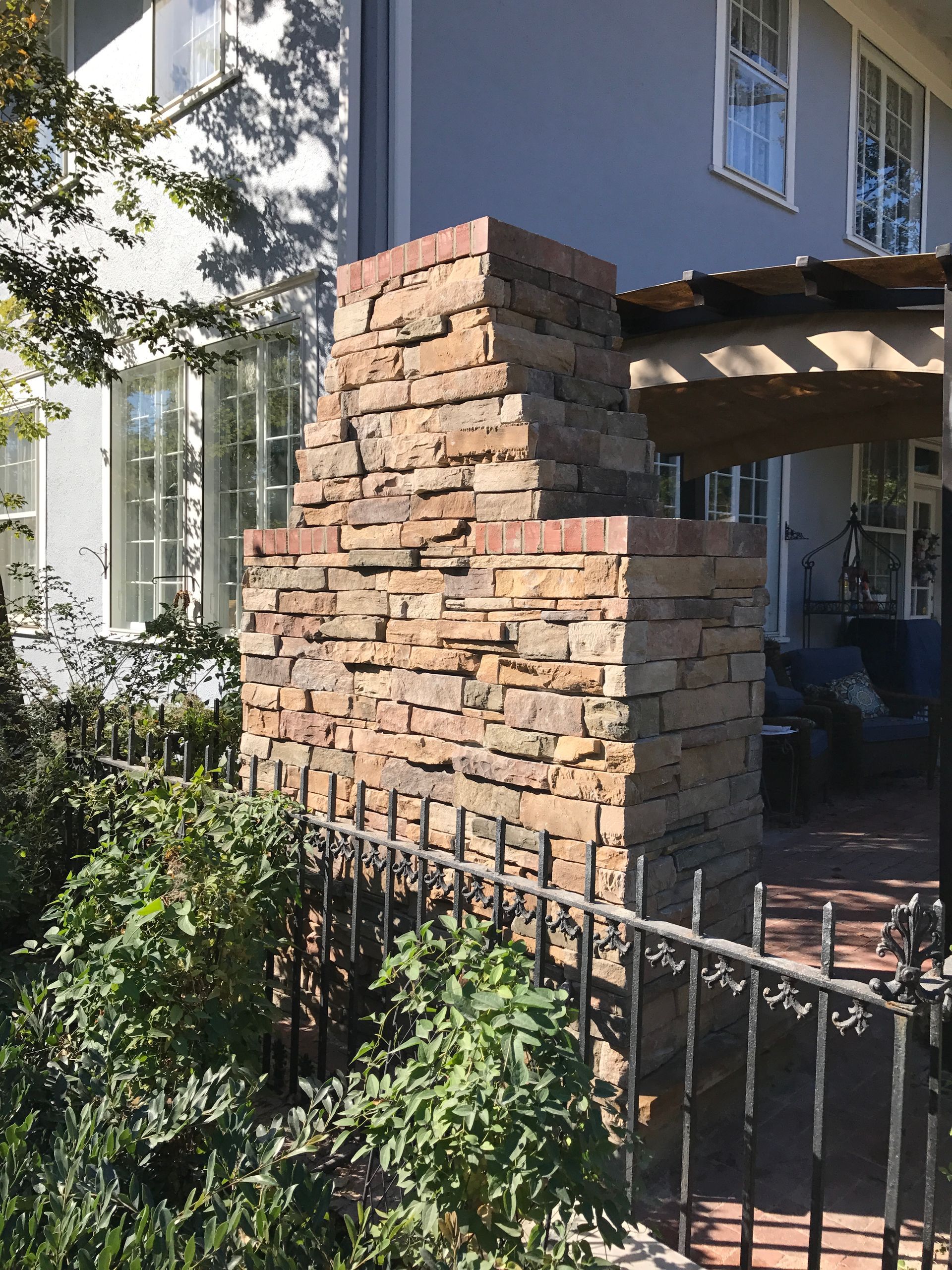 A brick chimney sits in front of a house