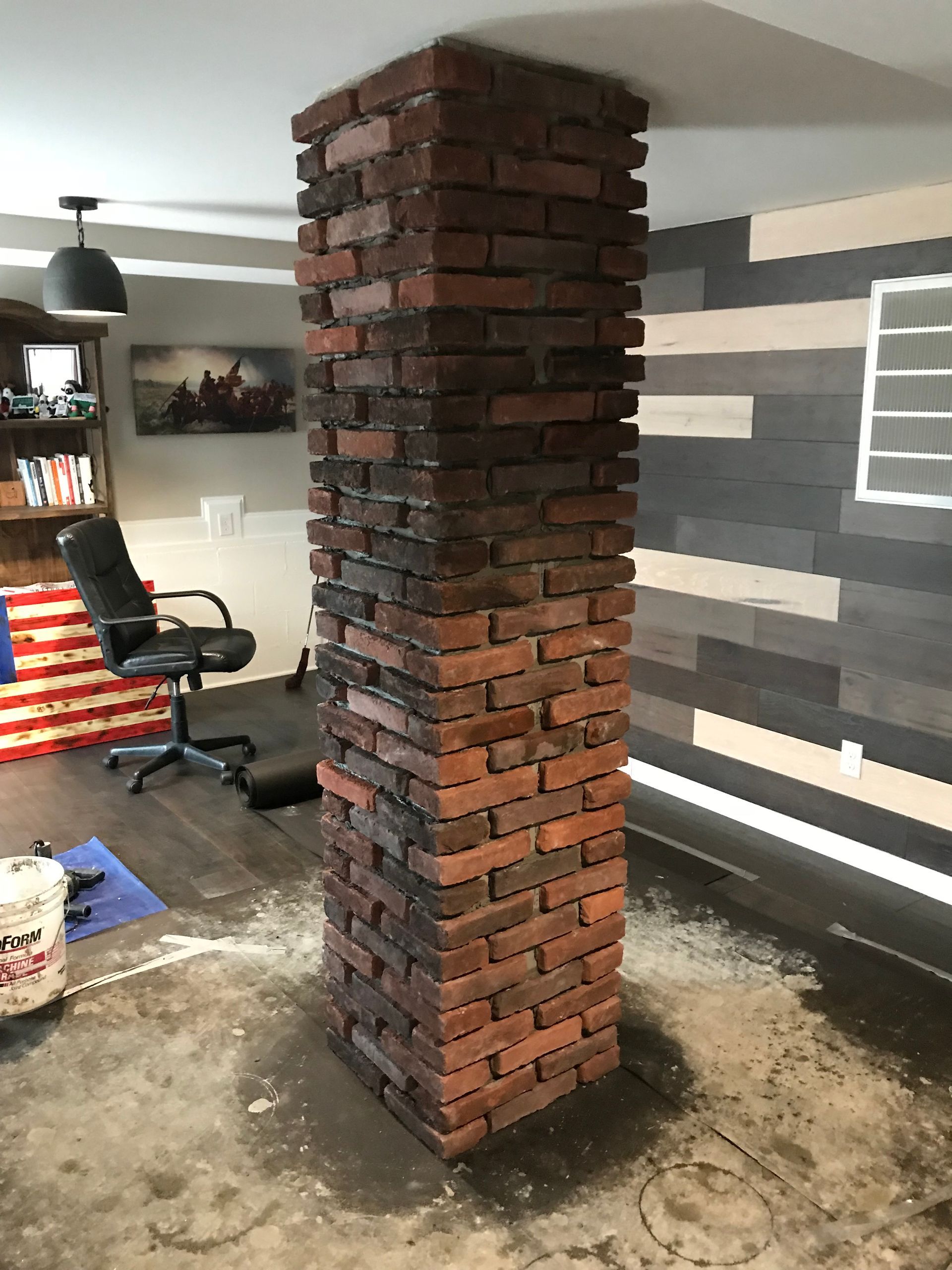A brick column in a living room with a chair