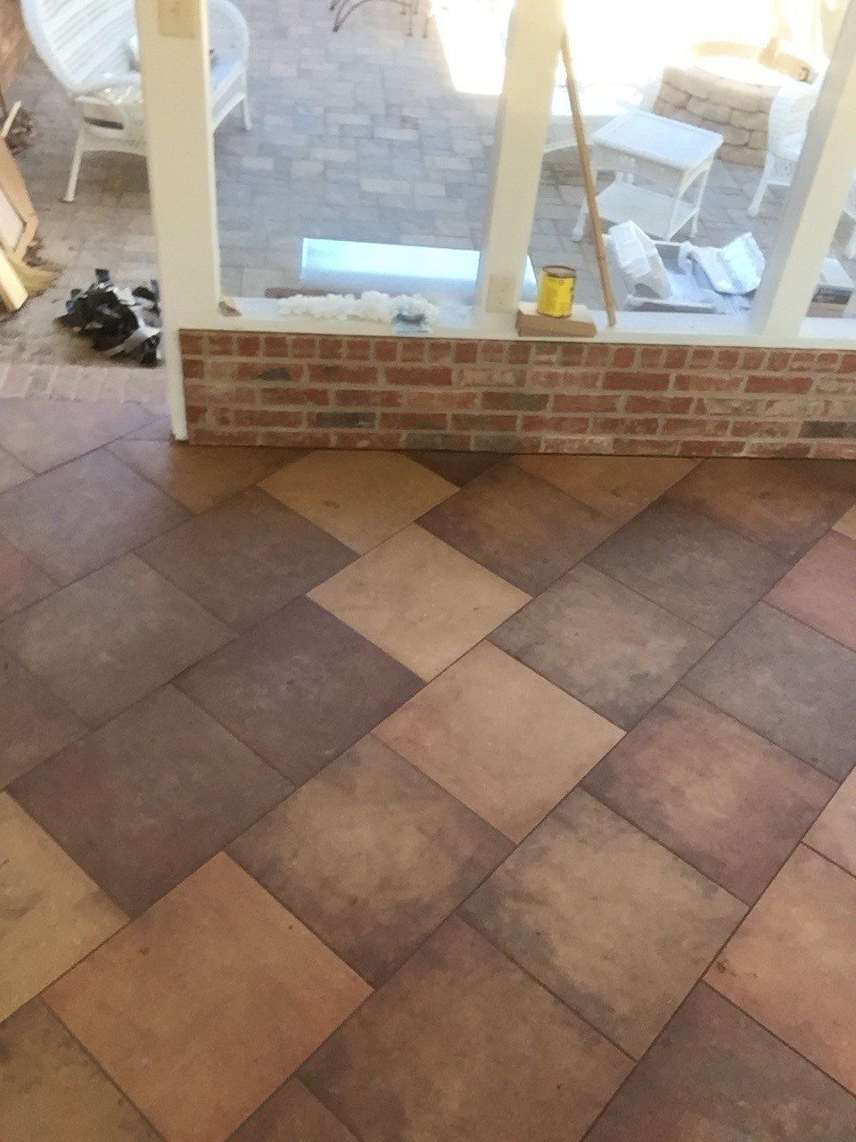 A tiled floor with a brick wall in the background
