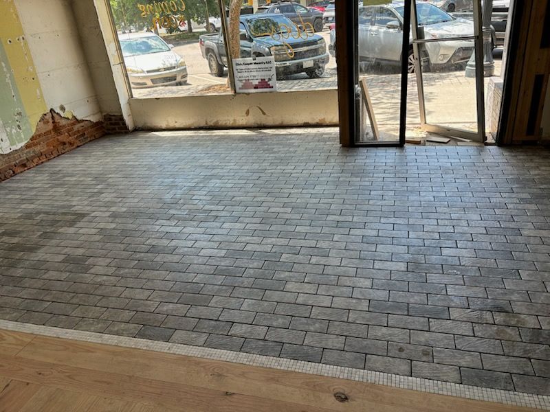 A room with a brick floor and a sliding glass door.
