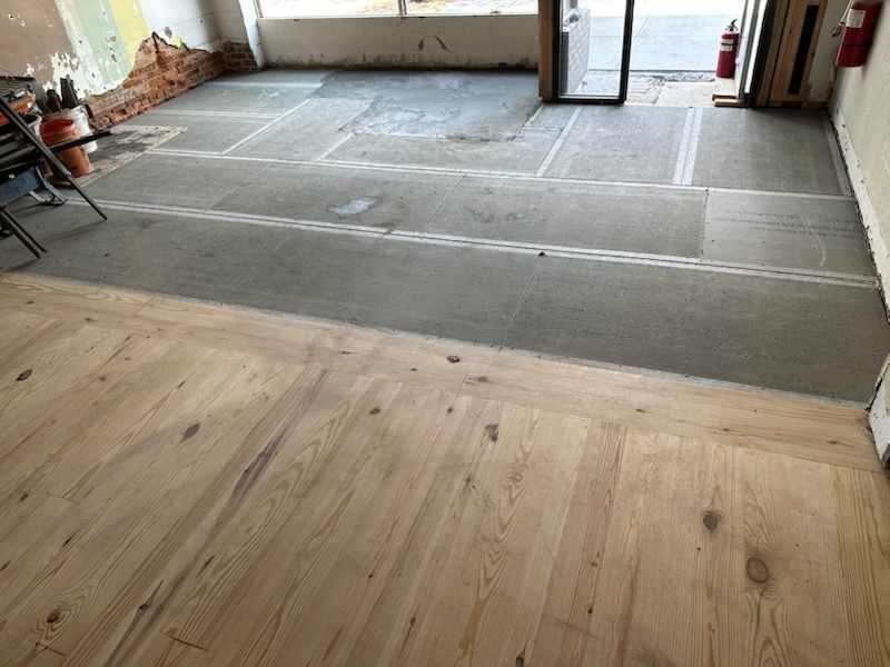 A room with a wooden floor and a concrete floor
