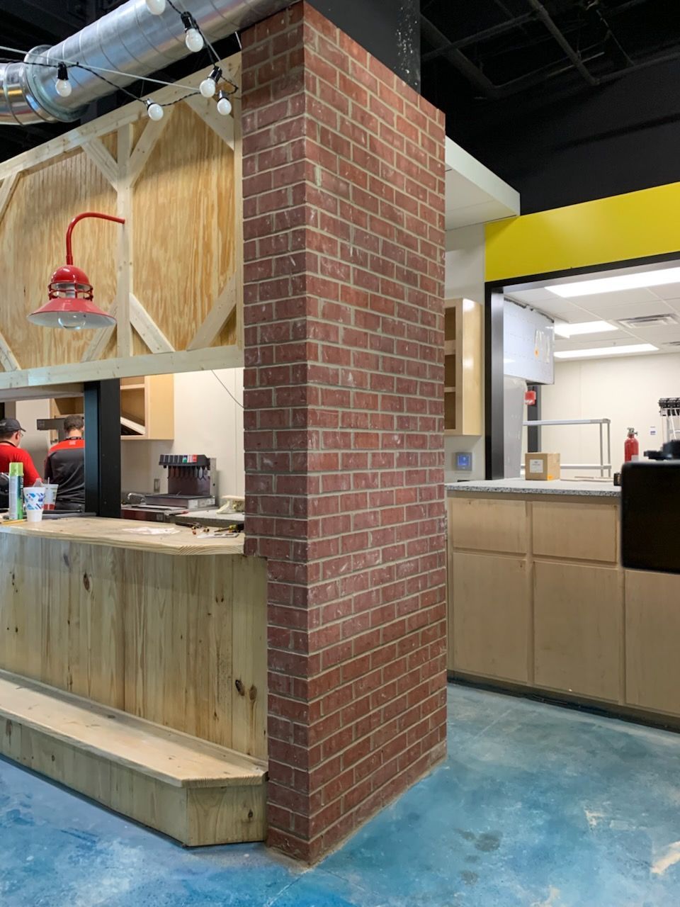 A restaurant with a brick wall and a wooden counter.
