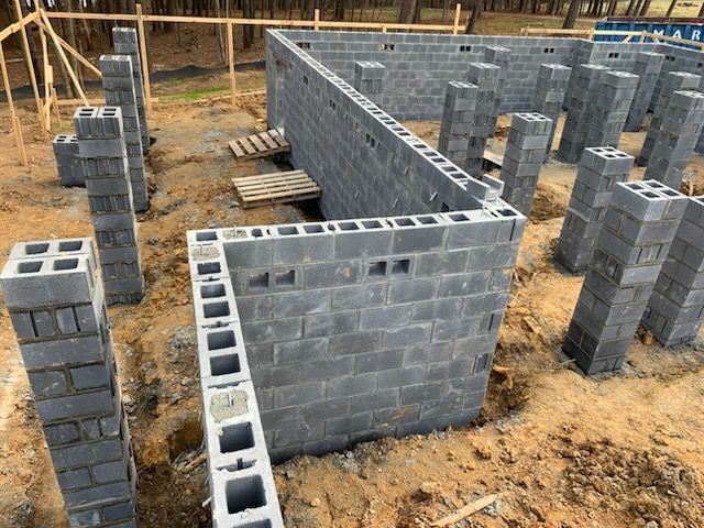 A brick wall is being built on a construction site.