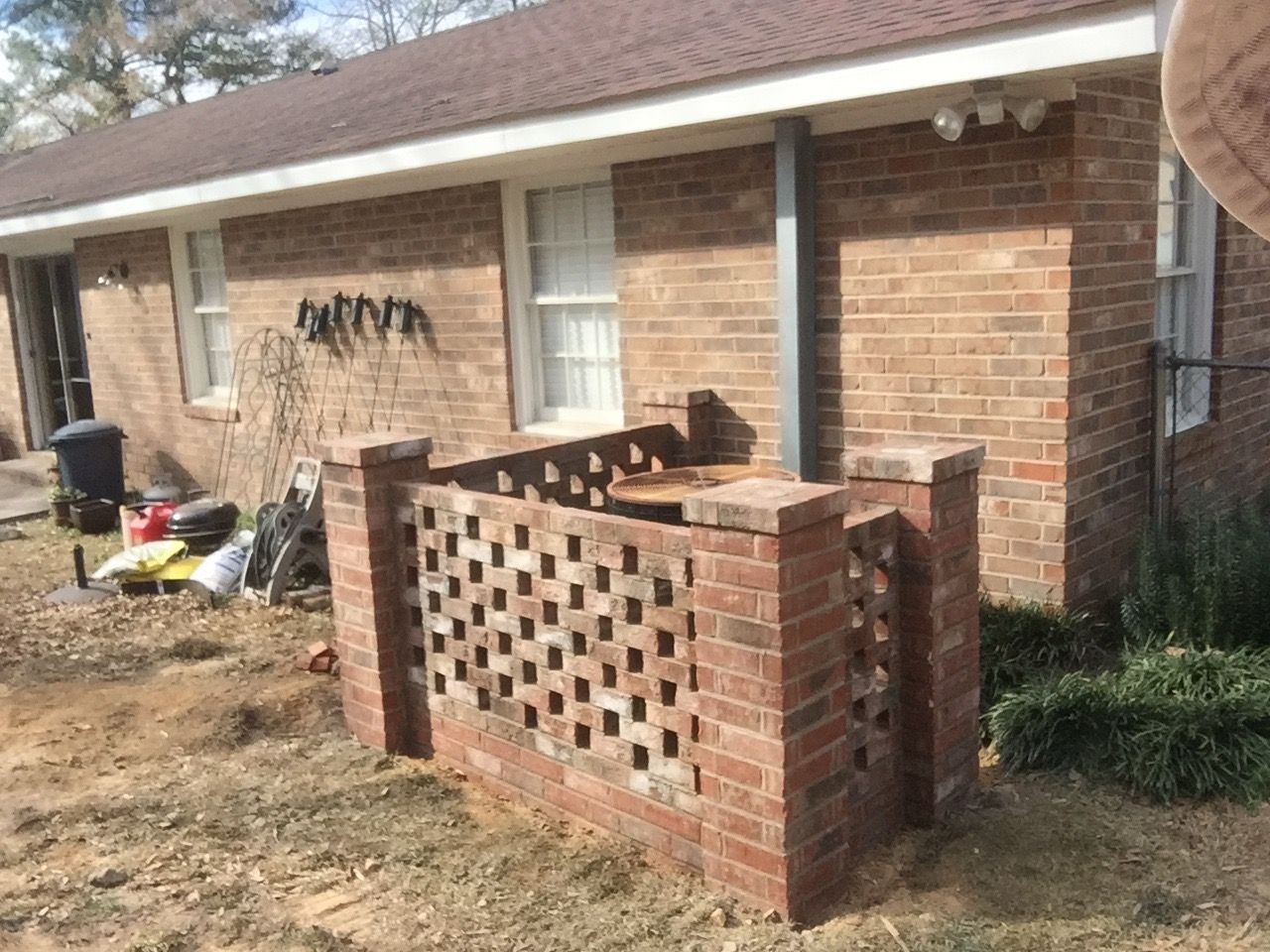 A brick house with a brick fence in front of it.
