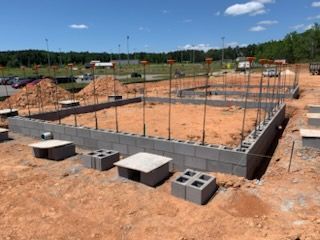 A concrete foundation is being built on a dirt field.