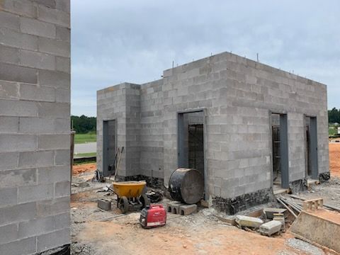 A building is being built with bricks and a wheelbarrow.