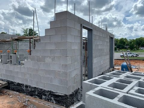A brick wall is being built on a construction site.