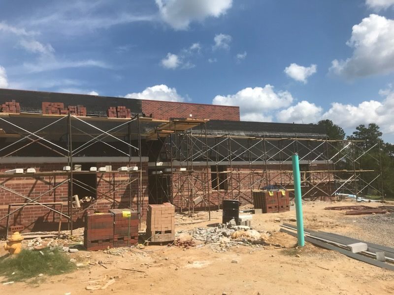 A brick building under construction with scaffolding around it