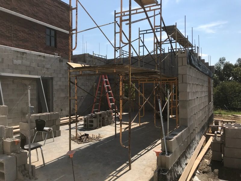 A building under construction with scaffolding and a ladder