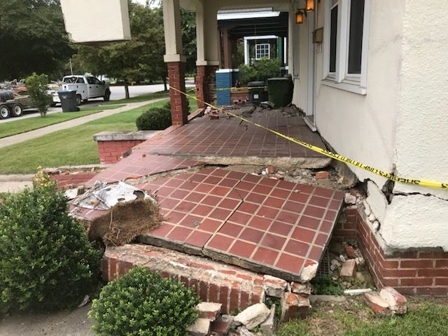 The front porch of a house has been damaged by an earthquake.