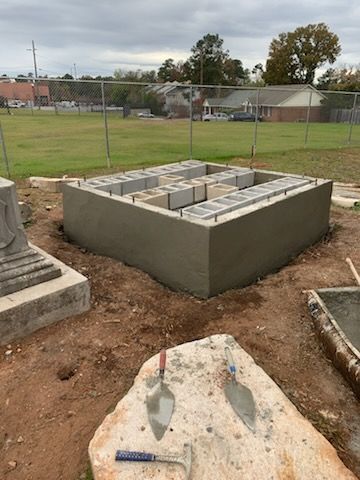 A large concrete block is being built in a field.