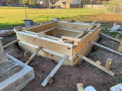 A wooden box is sitting on top of a dirt field.