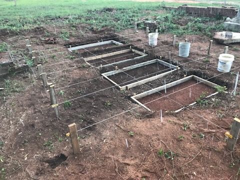A row of concrete blocks are sitting on top of a dirt field.