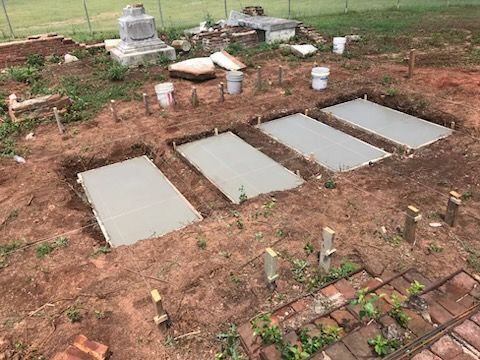 Three concrete slabs are sitting on top of a dirt field.