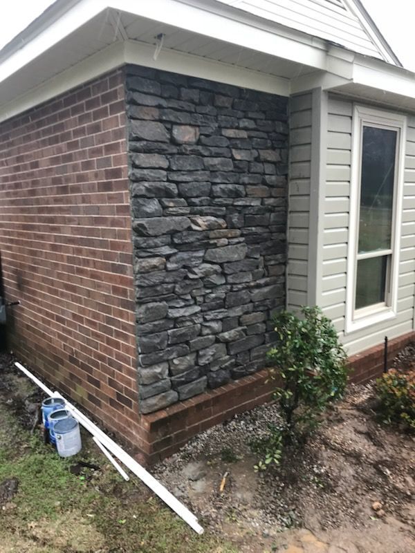 A brick building with a stone wall and a window.