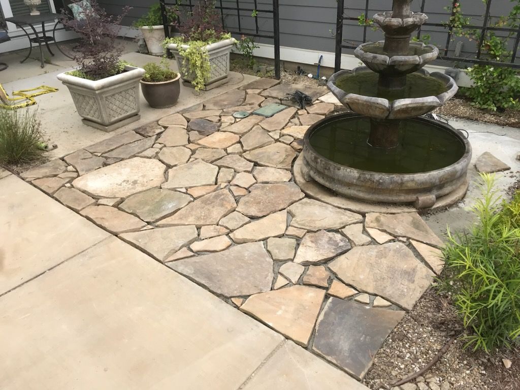 A stone walkway with a fountain in the middle of it.