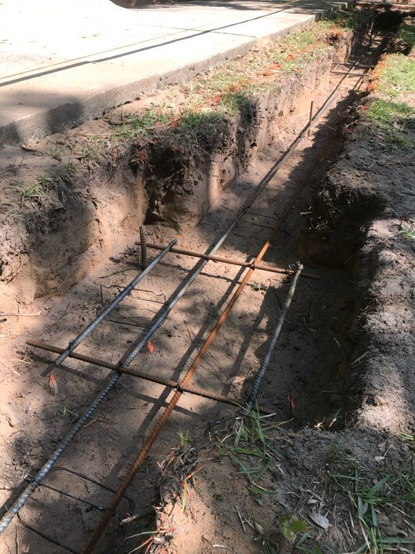 A metal fence is being built in a hole in the ground.